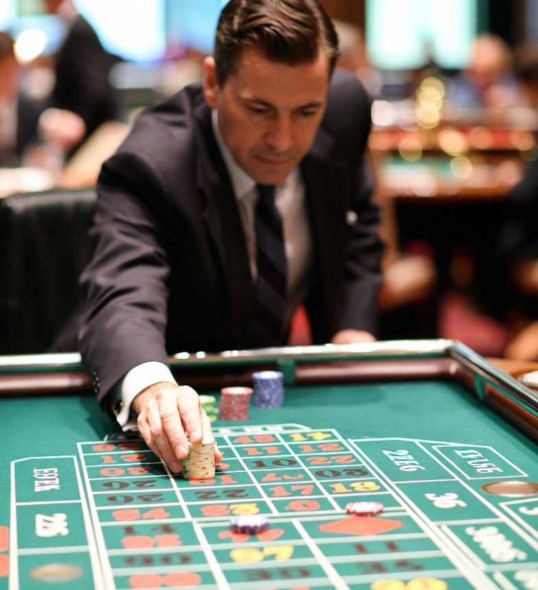 High roller player placing large chips on a roulette table
